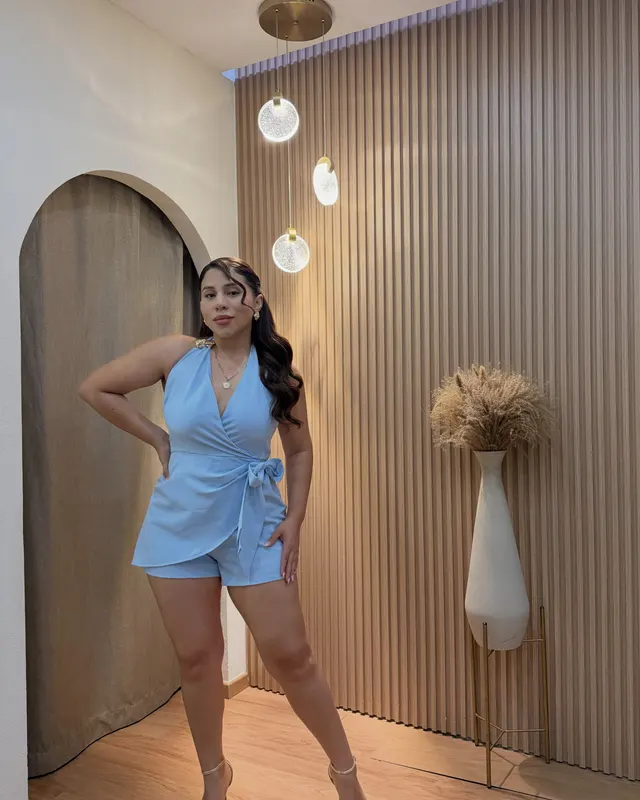 Romper azul cielo puesto, con sandalias doradas